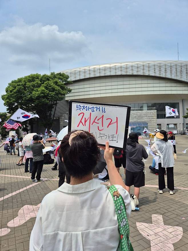 14일 서울 송파구 올림픽공원 핸드볼경기장 앞에서 직접 만든 '부정선거 재선거' 피켓을 들고 구호를 외치는 시민. 사진=김예지 기자