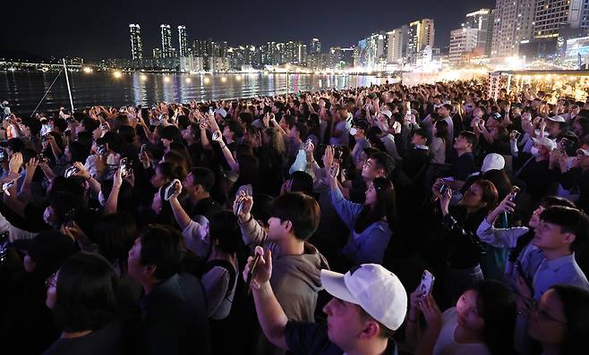 13일 밤 부산 수영구 광안리해수욕장에서 시민과 관광객들이 BTS 부산공연 기념 특별 드론쇼를 핸드폰에 담고 있다. 연합뉴스