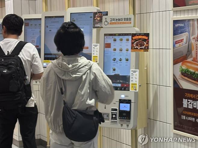 서울역 내 한 패스트푸드 전문점 키오스크 이용하는 고객 (서울=연합뉴스) 강민지 인턴기자 = 지난 8일 서울역 내 한 패스트푸드 전문점 키오스크 이용하는 고객. 2026.6.14