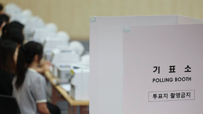 6·3 지방선거 사전투표를 하루 앞둔 지난달 28일 울산시 남구청 대강당에 마련된 사전투표소에 투표사무원들이 모의 투표를 하며 장비를 점검하고 있다. 연합뉴스