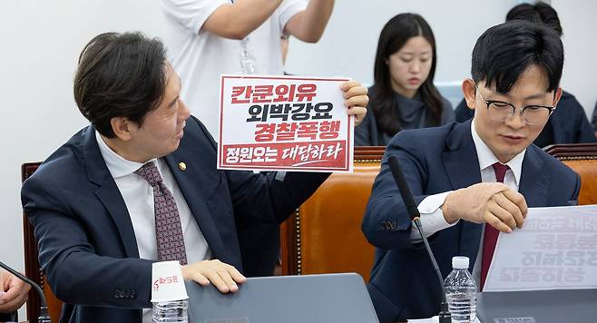 5월 18일 국회에서 열린 행정안전위원회 전체 회의에서 국민의힘 박수민(왼쪽), 박충권 의원이 민주당 정원오 서울시장 후보 폭행 사건의 의혹이 쓰여진 손팻말을 떼어내고 있다. 이날 행안위는 GTX-A 노선 삼성역 철근 누락 사건과 감사의 정원에 대한 현안 질의를 위해 열렸지만, 국민의힘 의원들의 민주당 정원오 서울시장 후보의 폭행 사건 의혹 제기와 민주당 의원들의 국민의힘 오세훈 서울시장 후보의 시장 재직 당시 철근 누락과 부실 공사 은폐 의혹이 충돌하면서 서울시장 선거 대리전 양상으로 진행됐다. 연합뉴스