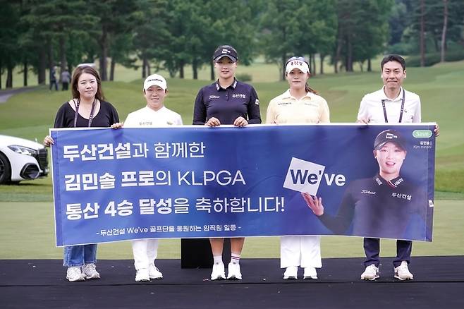 두산건설 We’ve 골프단 김민솔이 신지애(왼쪽 두 번째)와 고은혜(왼쪽 네 번째), 두산건설 임직원과 메르세데스-벤츠 제40회 한국여자오픈에서 우승한 뒤 기념촬영을 하고 있다. 사진 | 두산건설