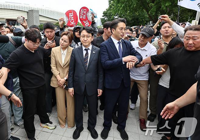 임오경, 전용기, 천준호 더불어민주당 의원이 17일 서울 송파구 올림픽공원 핸드볼경기장 앞에서 투표용지 부족 사태를 규탄하는 시민들에게 항의를 받으며 이동하고 있다. 2026.6.17 ⓒ 뉴스1 김도우 기자