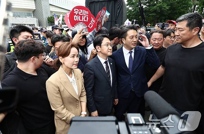 임오경, 전용기, 천준호 더불어민주당 의원이 17일 서울 송파구 올림픽공원 핸드볼경기장 앞에서 투표용지 부족 사태를 규탄하는 시민들에게 항의를 받으며 이동하고 있다. 2026.6.17 ⓒ 뉴스1 김도우 기자