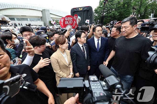 임오경, 전용기, 천준호 더불어민주당 의원이 17일 서울 송파구 올림픽공원 핸드볼경기장 앞에서 투표용지 부족 사태를 규탄하는 시민들에게 항의를 받으며 이동하고 있다. 2026.6.17 ⓒ 뉴스1 김도우 기자