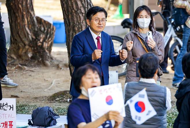 황교안(왼쪽) 자유와혁신 대표가 9일 서울 송파구 올림픽공원 핸드볼경기장 앞에서 열린 '개표소 봉쇄 시위'에 참석해 두 주먹을 불끈 쥐고 있다. 뉴시스