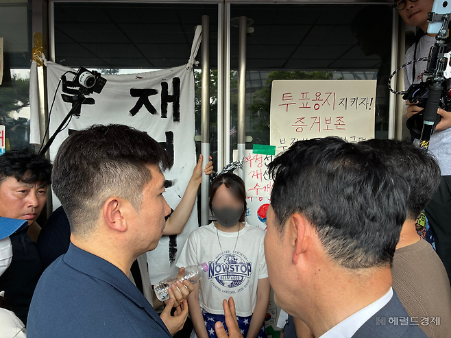 16일 오후 2시45분께 서울 송파구 올림픽공원 핸드볼경기장 2-1 게이트 앞에서 입구를 열지 못하도록 막는 시민을 유승민 대한체육회장(왼쪽)과 장동혁 국민의힘 대표가 설득하고 있다. 김서현 수습기자