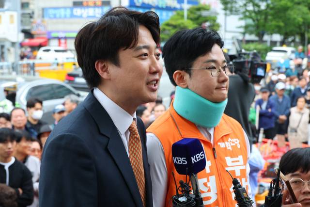 개혁신당 이준석 대표와 정이한 개혁신당 부산시장 후보가 4월 29일 부산 북구 구포시장을 찾아 발언하고 있다. 정이한 후보는 이틀 전인 4월 27일 시민이 던진 음료수를 피하다 다쳐 석고붕대를 하고 있다. 연합뉴스