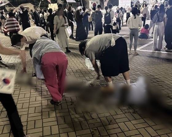 잠실 개표소 시위 참가자들이 바닥의 핏자국을 닦는 모습. 〈사진=연합뉴스〉