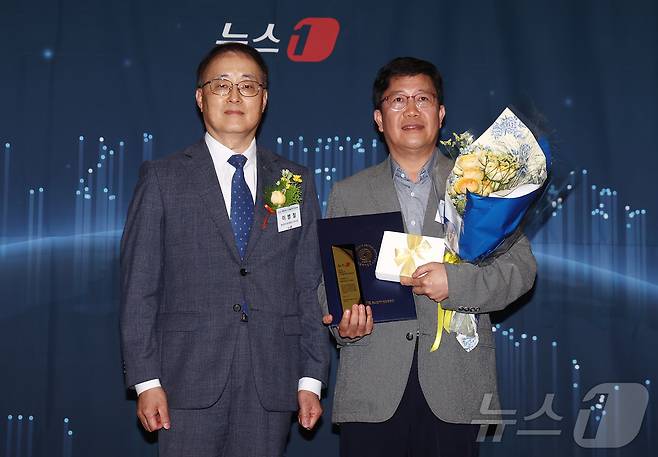 이병철 중소벤처기업진흥공단 부이사장이 17일 오후 서울 중구 프레스센터에서 '대한민국 중소기업의 힘, 디지털 혁신으로 글로벌 성장 잇다'를 주제로 열린 2026 뉴스1 대한민국 디지털성장기업대상 시상식에서 유주열 한솔피엔에스 주식회사 지원전략부문장에게 스마트테크상을 수여한 뒤 기념촬영을 하고 있다. 2026.6.17 ⓒ 뉴스1 김민지 기자