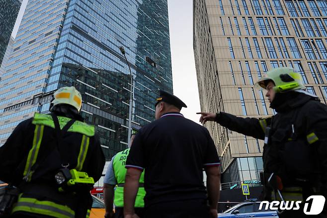 2023년 8월 1일(현지시간) 러시아 수도 모스크바 상업지구의 고층 건물이 무인기 공격을 받아 안전 요원들이 상황을 살피고 있다. 2023.08.01/ ⓒ 로이터=뉴스1