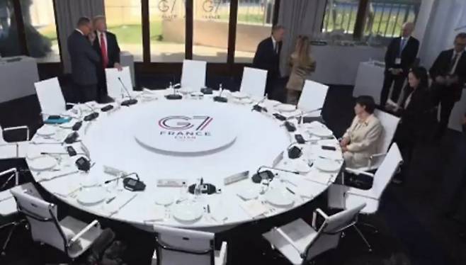 주요 7개국(G7) 정상회의 시작이 다소 연기된 동안 다카이치 사나에 일본 총리가 의자에 앉아 기다리고 있다. 주변에 도널드 트럼프 미국 대통령, 조르자 멜로니 이탈리아 총리 등 다른 정상들이 서서 서로 대화를 나누는 모습이 보인다. X(엑스) 캡처.