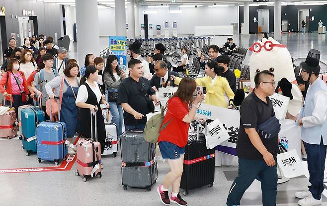 지난 1일 부산 강서구 김해공항 국제선 입국장에서 부산시와 부산관광공사 관계자들이 '중화권 집중 환대주간'을 맞아 스타럭스항공(대만) 신규 취항 첫 항공편을 이용해 부산을 방문한 관광객 180여 명을 대상으로 특별 환대 행사를 열고 있다. 사진 연합뉴스