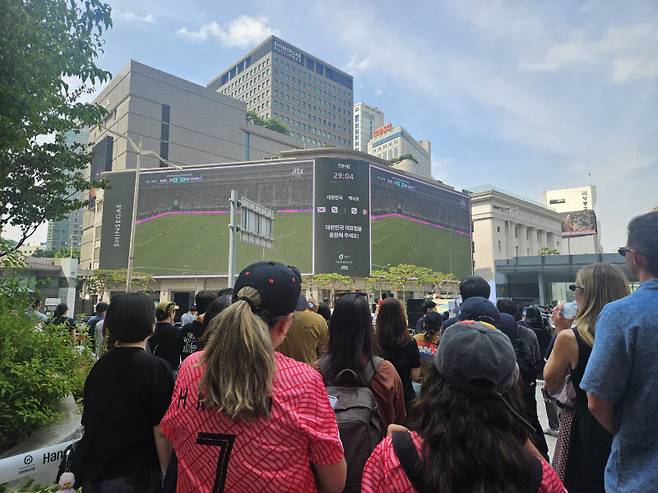 손흥민 유니폼을 입은 외국인 관광객들이 서울 명동 신세계스퀘어 앞에서 경기를 보며 응원하고 있다. (사진=김정유 기자)