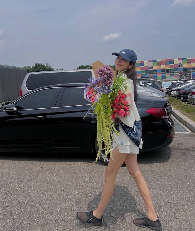 Singer Son Dam-bi shared an update on her life by posting a photo on her social media showing her smiling happily while holding a large bouquet. In the photo, Son Dam-bi drew attention by showcasing a hip fashion sense along with a slim, toned physique.On the 19th, Son Dam-bi posted several photos on her account showing her enjoying some relaxing time. She savored a happy Friday, posing on the road while holding a bouquet that appeared larger than her upper body.In particular, her lean figure stood out, complemented by a styling that matched sunglasses and a hat. Son Dam-bi also posted a photo taken from a top-down angle, jokingly asking if it was a shooting style typical of the MZ generation.Meanwhile, Son Dam-bi, born in 1983, married former speed skater Lee Kyu-hyuk in 2022 and has a daughter.