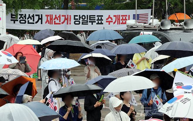 제9회 전국동시지방선거 투표용지 부족 사태를 규탄하는 개표소 봉쇄 시위가 계속된 20일 오전 서울 송파구 올림픽공원 핸드볼경기장 앞에서 시민들이 구호를 외치고 있다. 2026.6.20 ⓒ 뉴스1 김진환 기자