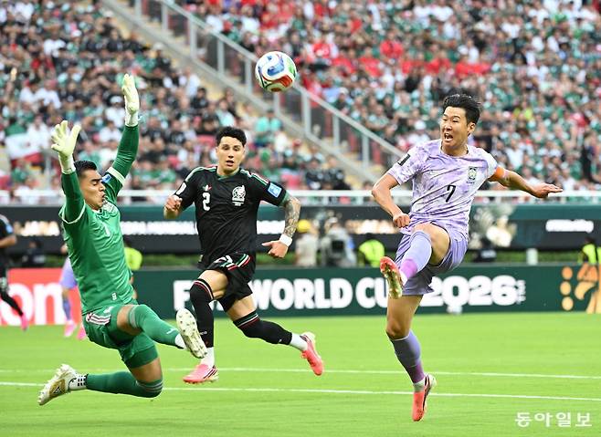 한국 축구 대표팀 ‘캡틴’ 손흥민(오른쪽)이 19일 멕시코와의 2026 북중미 월드컵 조별리그 A조 2차전 전반 16분 상대 골키퍼 라울 앙헬의 키를 넘기는 로빙슛을 시도하고 있다. 멕시코 수비수 에드손 알바레스가 이 공을 오버헤드킥으로 가까스로 걷어냈다. 이후 오프사이드 판정이 나오면서 이 슈팅은 공식 기록에서 빠지게 됐다. 
사포판=박형기 기자 oneshot@donga.com