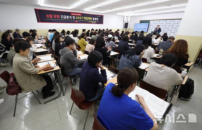 [서울=뉴시스] 김진아 기자 = 7일 서울 대치동 강남종로학원에서 열린 '6월 모의평가 긴급분석 및 2027 대입예측 설명회'에 참석한 학부모와 학생들이 설명을 듣고 있다. 2026.06.07. bluesoda@newsis.com
