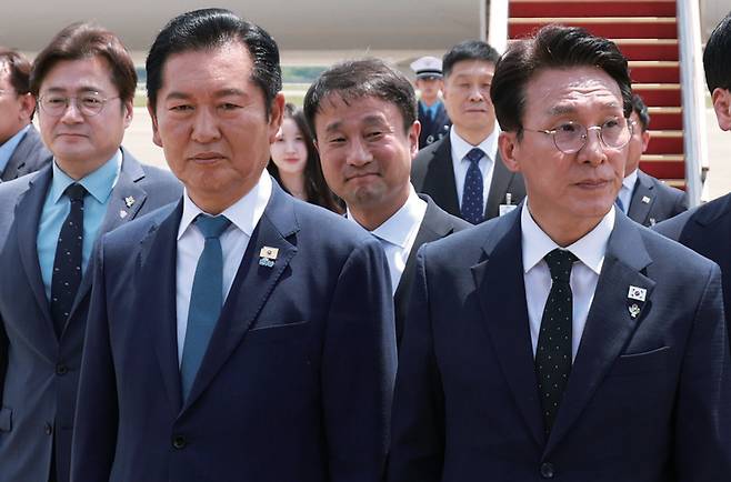 정청래 더불어민주당 대표와 김민석 총리가 6월18일 성남 서울공항에서 G7 정상회의와 유럽 순방을 마치고 귀국한 이재명 대통령과 인사를 나눈 뒤 의전 차량 이동을 기다리고 있다. ⓒ연합뉴스