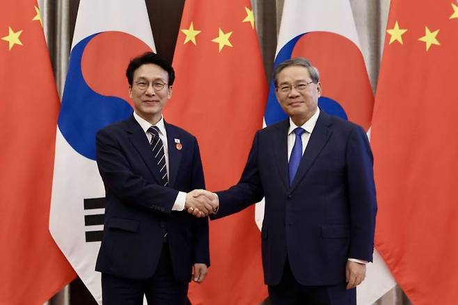 중국을 방문 중인 김민석 국무총리가 23일 중국 다롄의 방추도 호텔에서 리창 국무원 총리를 만나 회담에 앞서 악수하고 있다. 연합뉴스