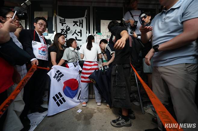 6·3지방선거 투표용지 부족 사태로 촉발된 잠실 개표소 봉쇄 시위가 12일째 이어진 16일 서울 송파구 올림픽공원 핸드볼경기장 개표소 앞에서 시민들이 국민의힘과 대한체육회 관계자들의 진입을 봉쇄하기 위해 문을 잡고 있다. 남동균 기자