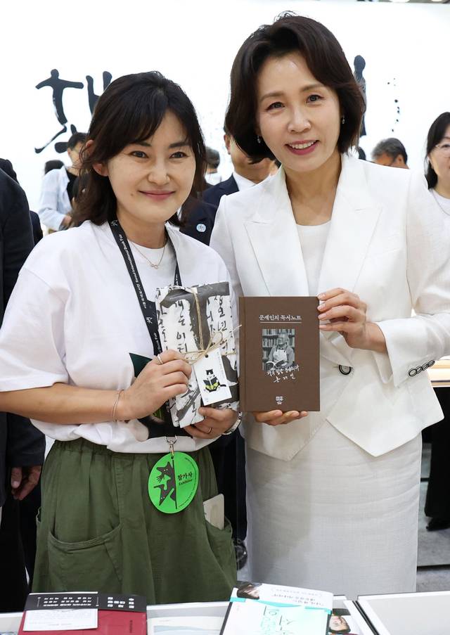 김혜경 여사가 24일 서울 강남구 코엑스에서 열린 서울국제도서전에서 문재인 전 대통령의 책을 들고 있다.[청와대통신사진기자단]
