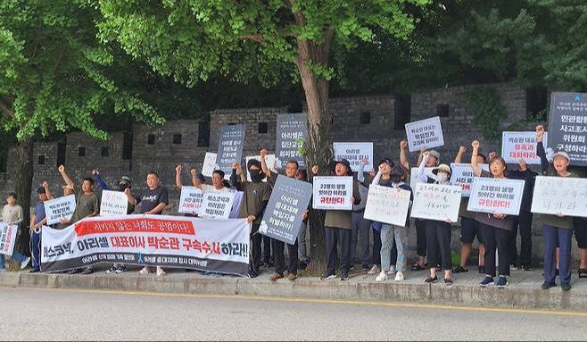 2024년 7월 아리셀 참사 유가족과 시민사회단체 관계자들이 경기남부경찰청 앞에서 수사정보 공유와 아리셀 대표 구속 등을 외치며 시위하고 있다. 연합뉴스