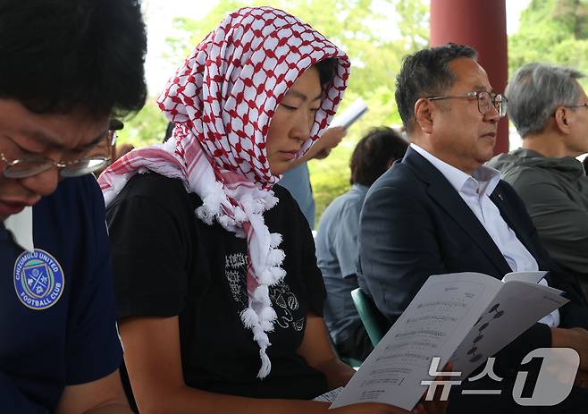 5월23일 오전 광주 북구 운정동에 위치한 국립 5·18민주묘지 역사의문 앞에서 열린 제21회 들불상 시상식에 앞서 김아현 씨(활동명 해초)가 자료집을 살펴보고 있다. 김 활동가는 최근 팔레스타인 가자지구로 향하던 선박에 탑승했다가 이스라엘군에 억류됐다 귀국했다. 2026.5.23 ⓒ 뉴스1 박지현 기자
