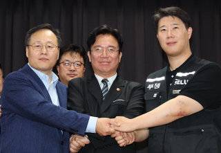 5월 20일 경기 수원시 장안구 경기고용노동청에서 열린 삼성전자 임금협상에서 여명구 DS 부분 피플팀장, 김영훈 고용노동부 장관, 최승호 초기업노조 삼성전자지부 위원장(왼쪽부터)이 잠정 합의안에 서명한 뒤 손을 맞잡고 있다. 사진공동취재단