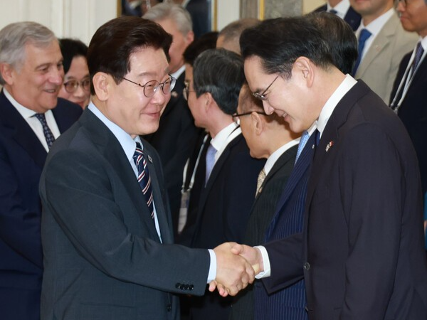 이재명 대통령이 12일(현지시간) 이탈리아 로마의 한 호텔에서 열린 비즈니스 라운드테이블에 입장하며&nbsp;이재용&nbsp;삼성전자 회장과 악수하고 있다.&nbsp; 연합뉴스