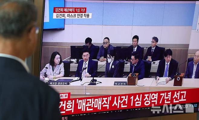 [서울=뉴시스] 조성우 기자 = 26일 서울 중구 서울역 대합실에서 시민들이 특정범죄 가중처벌법상 알선수재 혐의로 기소된 김건희 여사에 대한 1심 선고 공판 생중계를 보고 있다. 2026.06.26. xconfind@newsis.com