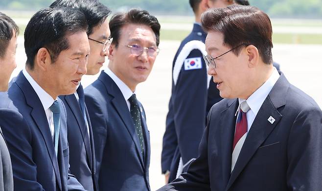주요 7개국(G7) 정상회의 일정을 마친 이재명 대통령이 지난 18일 경기 성남 서울공항에 도착해 정청래 더불어민주당 대표와 인사를 나누고 있다. /뉴스1
