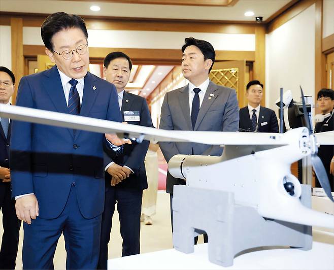 “기술 우위가 안보 우위”  이재명 대통령이 26일 청와대에서 열린 ‘미래 신(新)안보 혁신기업 육성 전략회의’에 참석해 정찰용 무인항공기를 살펴보고 있다. 이 대통령은 이날 회의에서 “기술 우위가 곧 안보 우위”라며 “대한민국이 전통적인 방산 강국에서 글로벌 신안보 강국으로 거듭나려면 국가 차원의 신안보 혁신기업 육성이 무엇보다 중요하다”고 했다. /뉴스1