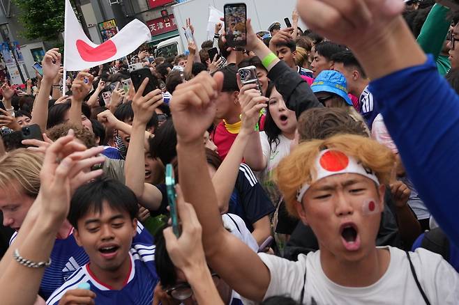 ▲ 26일 미국에서 열린 월드컵 F조 경기에서 일본이 스웨덴과 무승부를 기록하며 다음 라운드에 진출하자 팬들이 도쿄 시부야 교차로에 모여 환호하고 있다. AP/연합뉴스