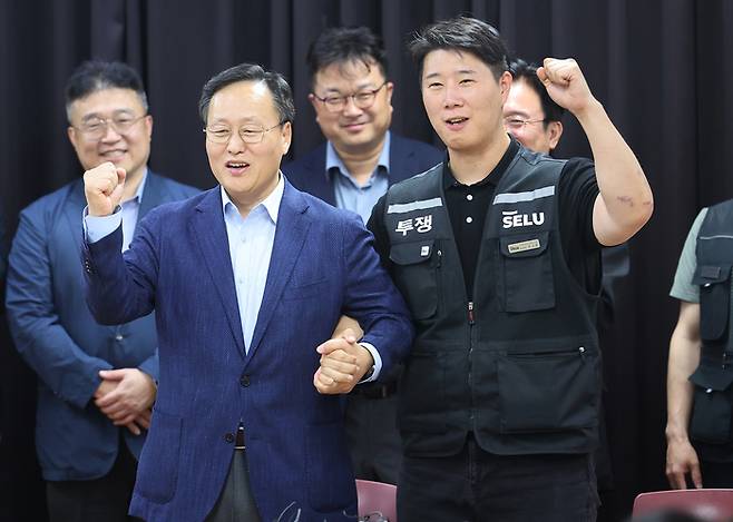지난달 20일 경기도 수원시 장안구 경기고용노동청에서 열린 삼성전자 임금 협상을 마친 후 여명구 삼성전자 디바이스솔루션(DS) 피플팀장(오른쪽)과 최승호 삼성그룹 초기업노동조합 삼성전자지부(초기업노조) 위원장이 잠정 합의안에 서명 후 파이팅을 외치고 있다. [연합뉴스]