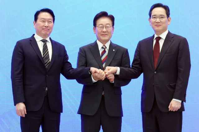 이재명 대통령과 이재용 삼성전자 회장, 최태원 SK그룹 회장이 지난 29일 청와대에서 열린 3대 메가프로젝트 국민보고회에서 기업 투자계획 발표 후 손을 잡고 있다. 연합뉴스