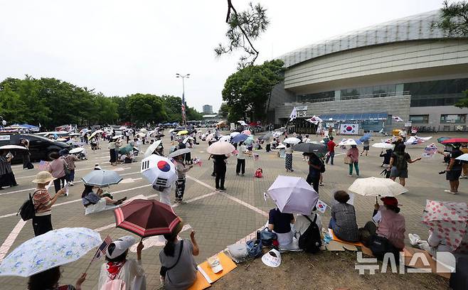 [서울=뉴시스] 홍효식 기자 = 투표용지 부족 사태에 항의하는 개표소 봉쇄 시위가 26일째 이어지고 있는 30일 오후 서울 송파구 올림픽공원 핸드볼경기장 앞에서 참가자들이 태극기와 성조기를 흔들며 "부정선거, 재선거, 당일투표, 수개표"를 외치고 있다. 2026.06.30. yesphoto@newsis.com