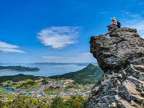 풍경의 완성은 사람이다. 암릉 너머 신금산이 보인다.