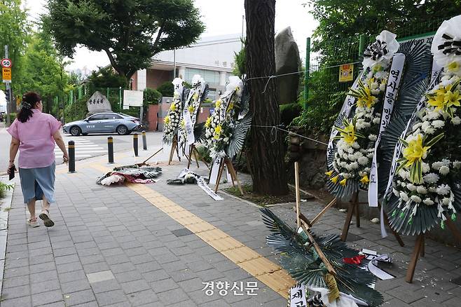 한 학부모가 근조화환을 보며 지나가고 있다.