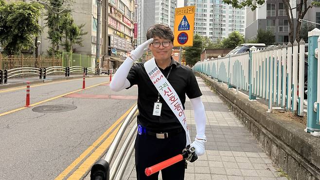 30일 오전 9시10분쯤 경기 구리시 동인초등학교 앞 삼거리에서 교통봉사를 마친 양신현(58)씨가 ‘신호등 아저씨’ 어깨띠를 두르고 경례 자세를 취하고 있다. 허은선 인턴기자