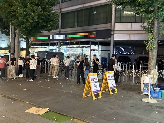 서울 종로3가 야장 거리의 금연 안내판 앞에서 시민들이 흡연하는 모습. 남소정 기자