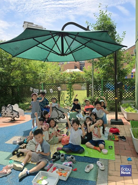 천왕숲어린이집에 설치된 그늘막 아래에서 어린이들이 놀이활동을 하고 있다.&nbsp;ⓒ구로구