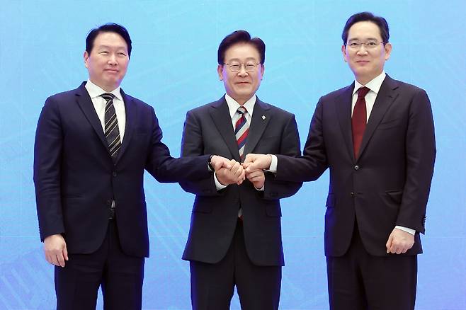 이재명 대통령과 이재용 삼성전자 회장, 최태원 SK그룹 회장이 29일 청와대에서 열린 3대 메가프로젝트 국민보고회에서 기업 투자계획 발표 후 손을 잡고 있다. 2026.6.29 [청와대통신사진기자단] <연합뉴스>