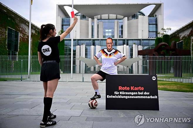 "메르츠에 레드카드" 퍼포먼스 [AFP=연합뉴스 자료사진. 재판매 및 DB 금지]