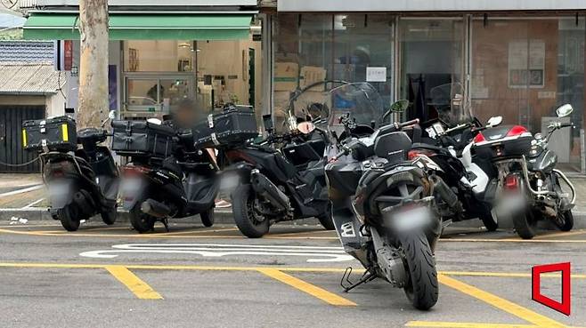 서울 마포구 서울서부지법 인근 도로 안전지대에 오토바이들이 줄지어 불법 주차돼 있다. 황색 빗금이 그려진 안전지대는 차량과 보행자의 안전을 위해 비워둬야 한다. 이지예 기자
