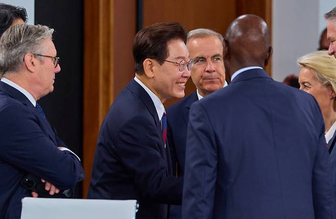 이재명 대통령이 G7 초청국 확대회담 2세션에서 참석자들과 대화하고 있다. 연합뉴스