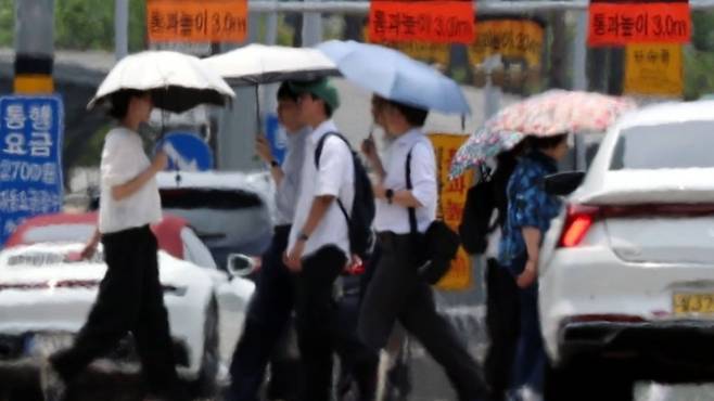 서울 영등포구 여의도공원 앞 도로 위로 아지랑이가 피어오르는 가운데 시민들이 횡단보도를 건너고 있다. /사진=연합뉴스