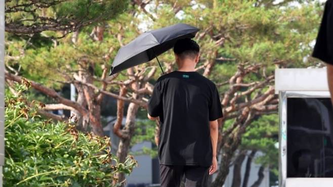 광주 삼성전자 그린시티1·2캠퍼스에서 검은 양산을 쓴 직원이 출근하고 있다. /사진=연합뉴스