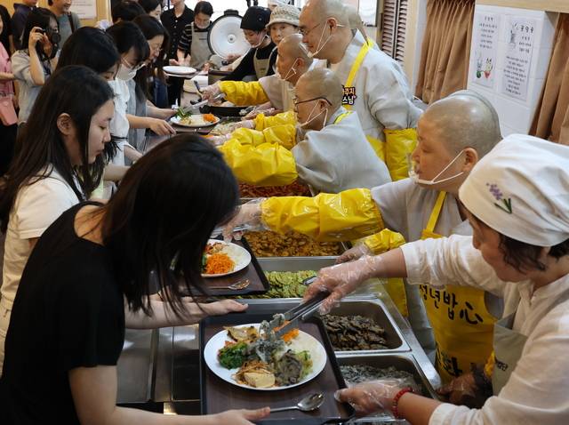 지난달 16일 서울 동대문구 연화사에서 열린 사찰 인근 대학생 점심 제공 행사 ‘청년밥심’에서 선재스님(오른쪽 세번째)이 배식을 하고 있다. 조계종은 시대의 변화에 따라 포교방식이 바뀌어야 한다는 판단에 오는 8일 이를 위한 토론회를 개최한다. 연합뉴스