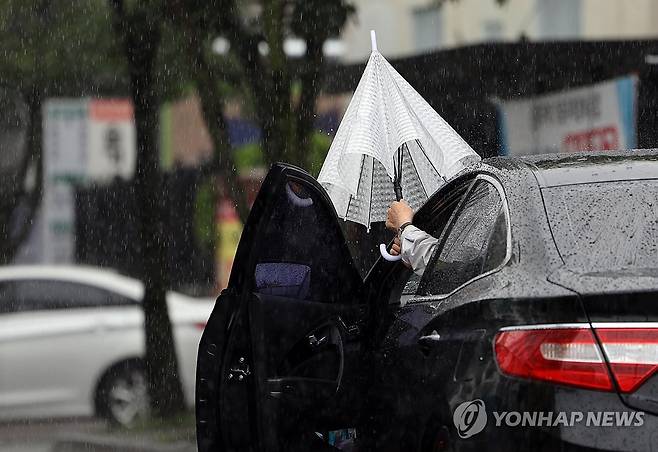 '비 오네' (전주=연합뉴스) 정경재 기자 = 5일 정체전선 영향으로 비가 내리는 전북대학교 대학가에서 한 운전자가 우산을 펴고 있다. 2026.7.5 jaya@yna.co.kr